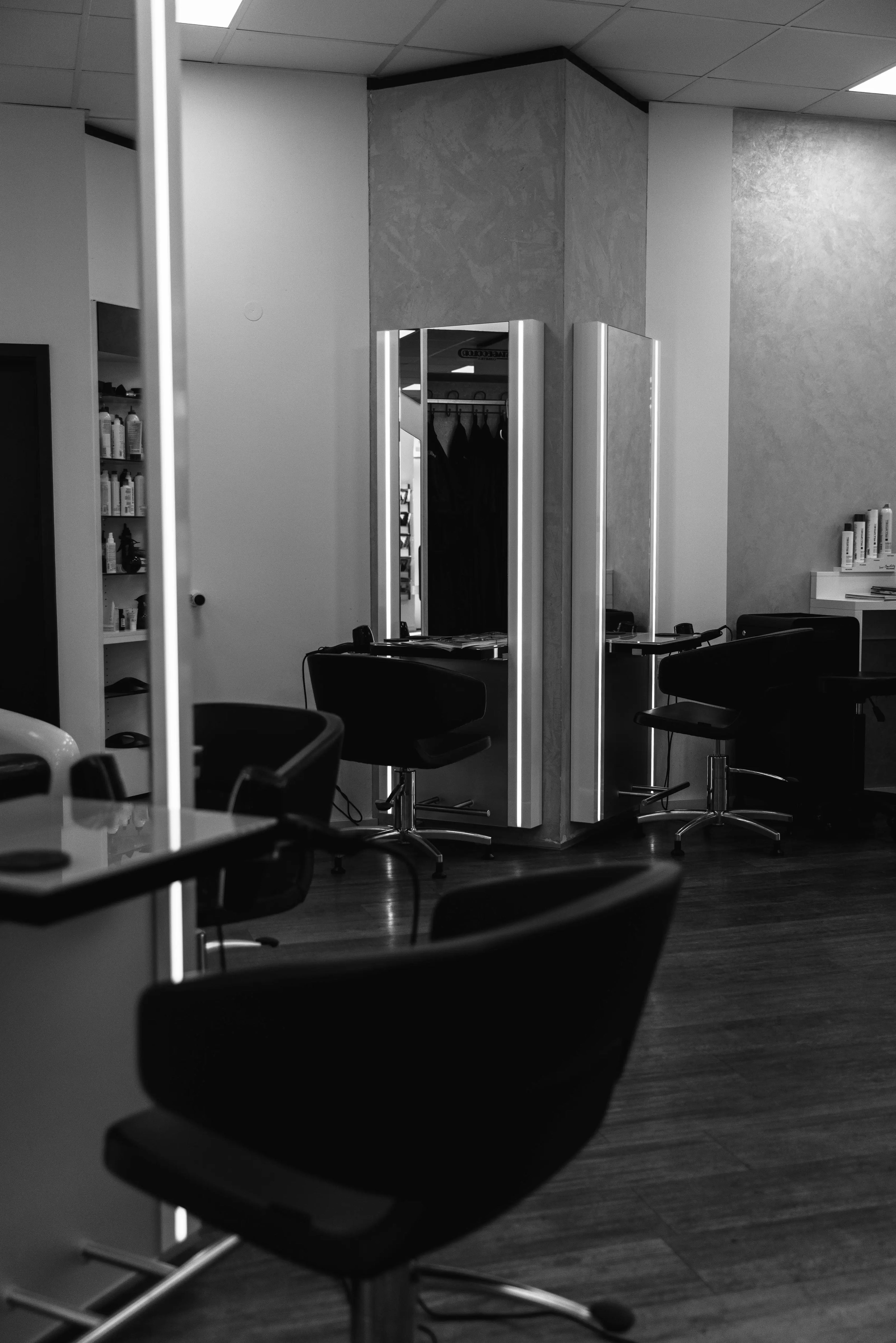 Innenansicht des Coiffeur Hofstetter Salons mit modernen Friseurstühlen und Haarpflegeprodukten im Regal