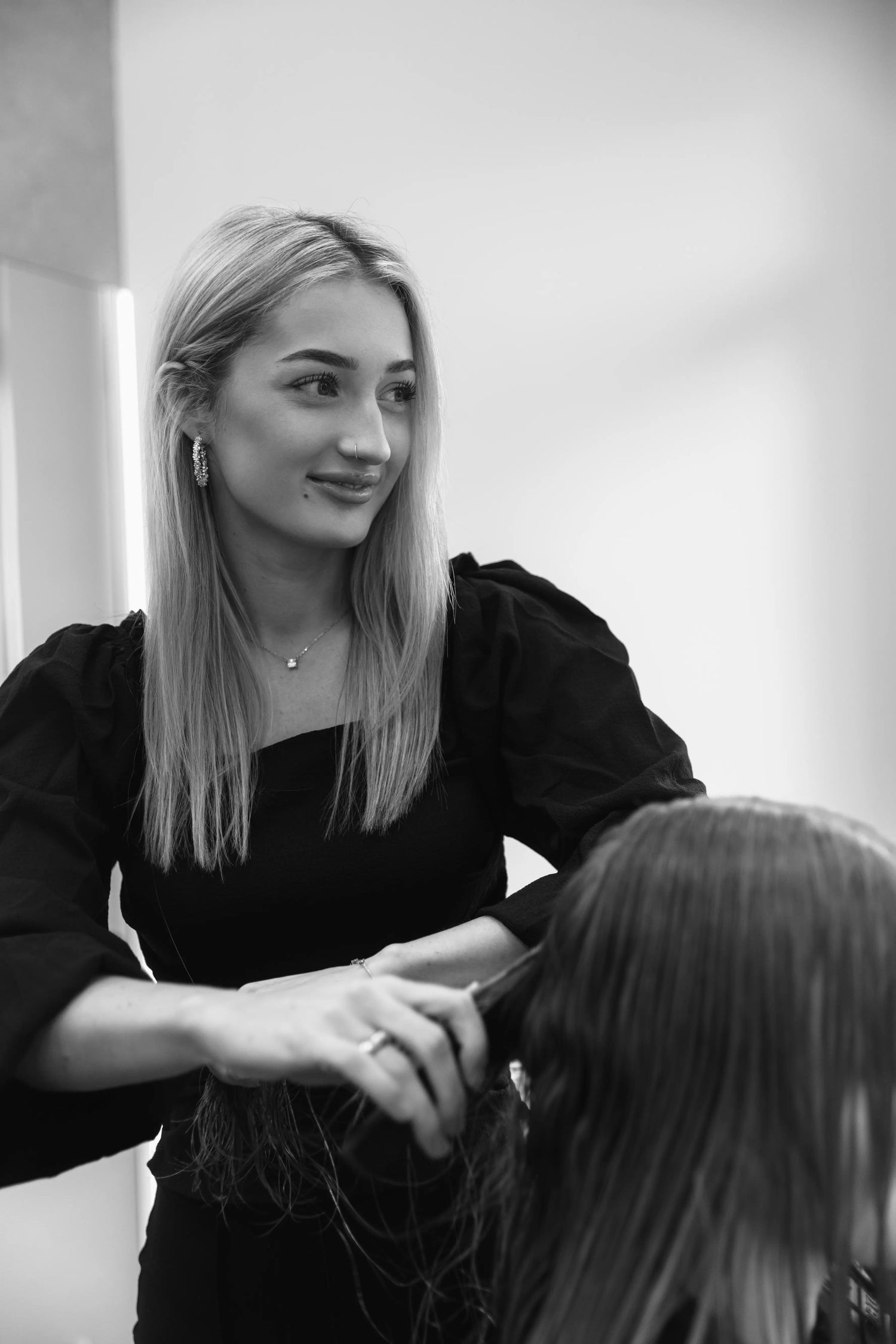 Erfahrene Friseurin, spezialisiert auf Farbveränderungen und Herrenhaarschnitte, arbeitet an einem Kunden. Sie verleiht jedem Haarschnitt einen individuellen Look.