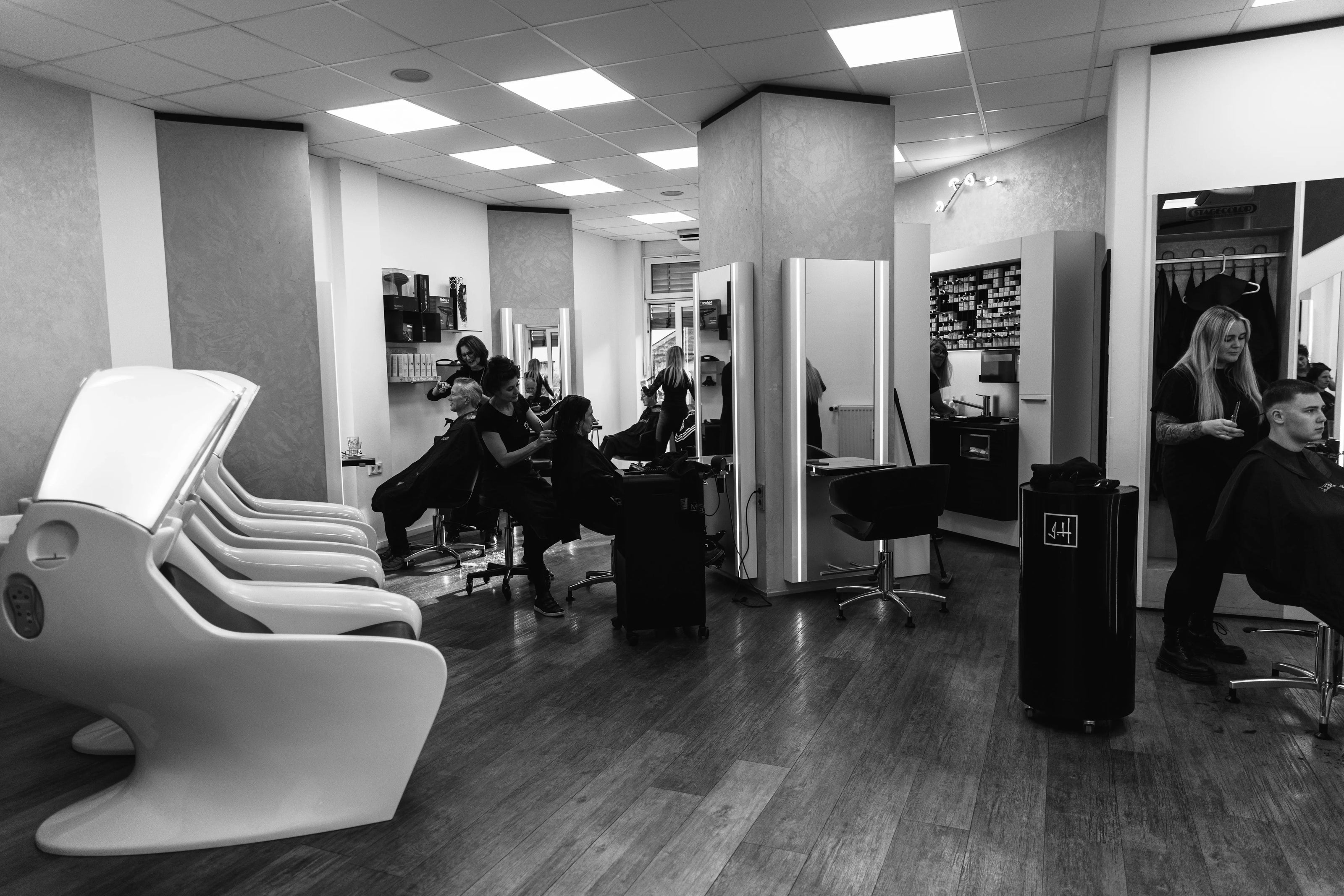 Friseure des Coiffeur Hofstetter Salons beim Schneiden und Stylen der Haare von Kunden